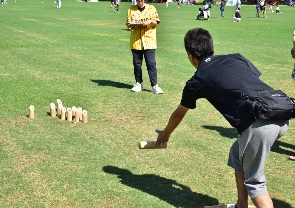 モルックのピンとモルックを持つ参加者